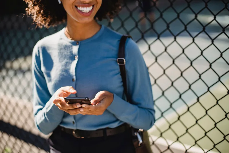 Woman using her smartphone outdoors, checking a notification