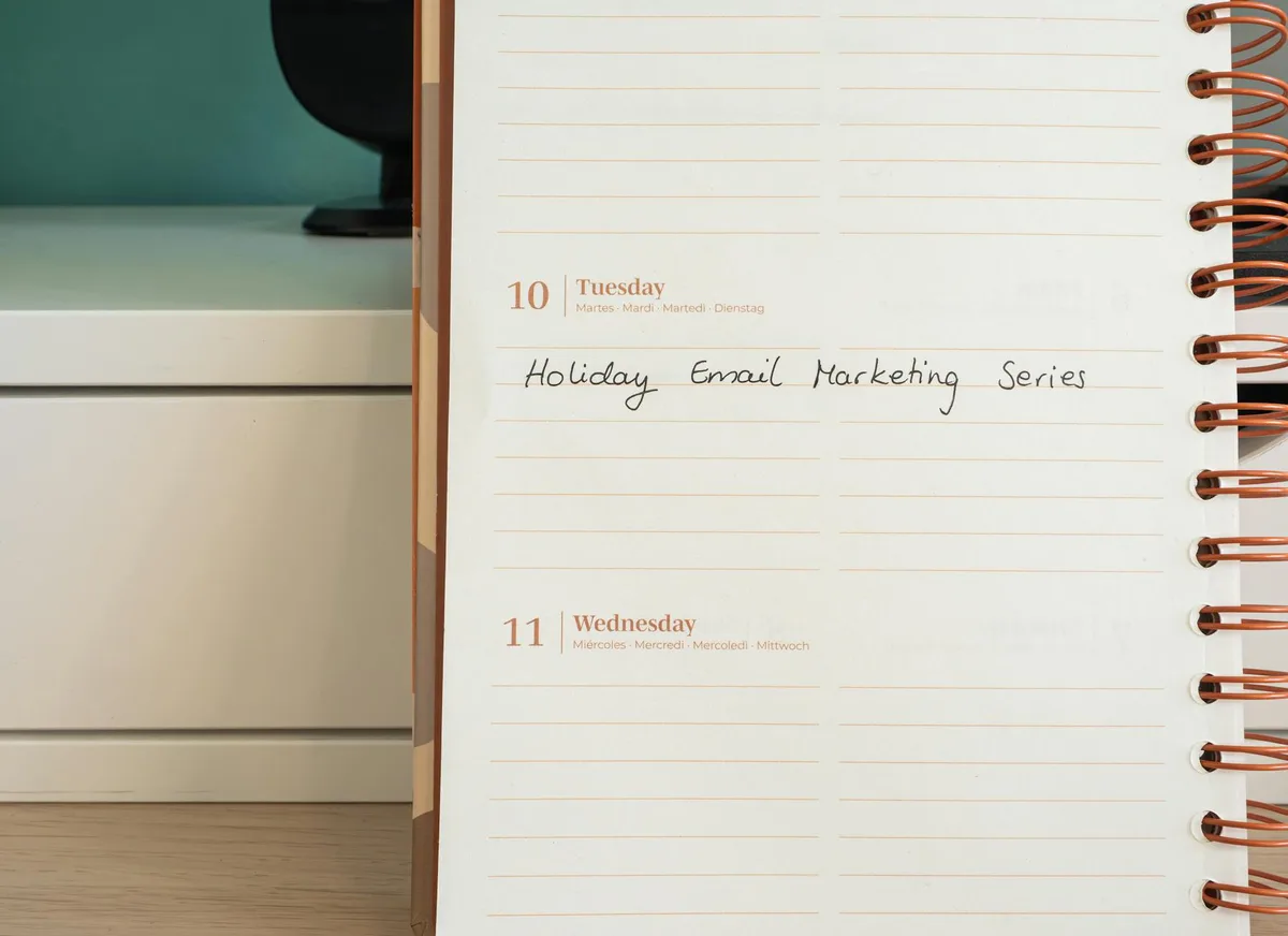 A planner open on a desk with handwritten email marketing series notes, representing a structured launch sequence