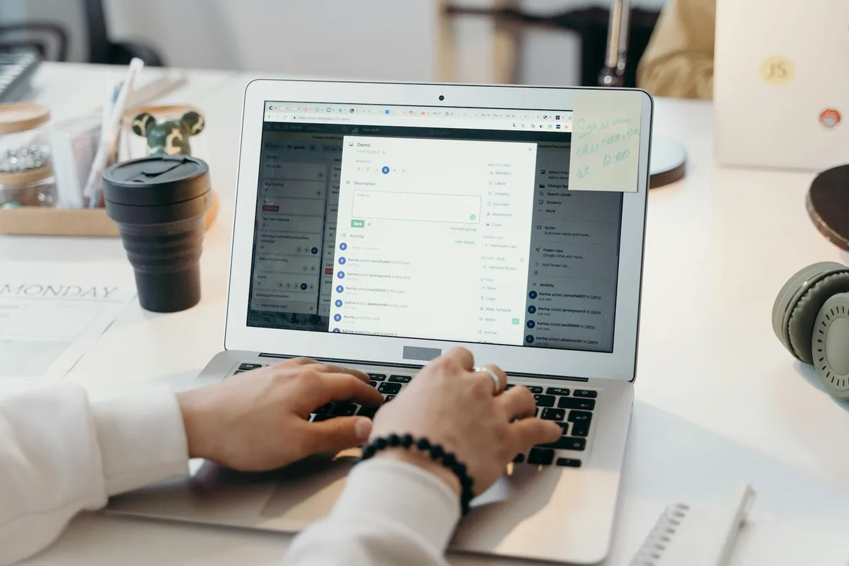 A solo creator setting up email automation on a laptop at a clean, organized desk