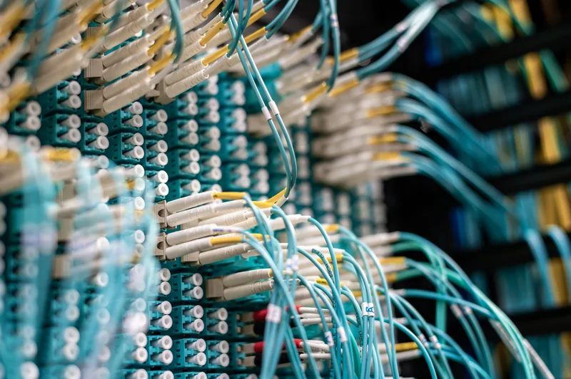 Close-up view of thin cables connected to a row of small connectors, representing the connections inside a system