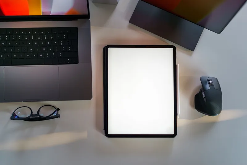 Laptop and blank tablet mockup on a desk, representing a digital product page layout