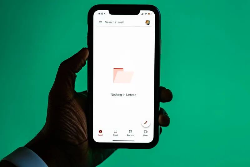 Hand holding a smartphone with an email signup screen open