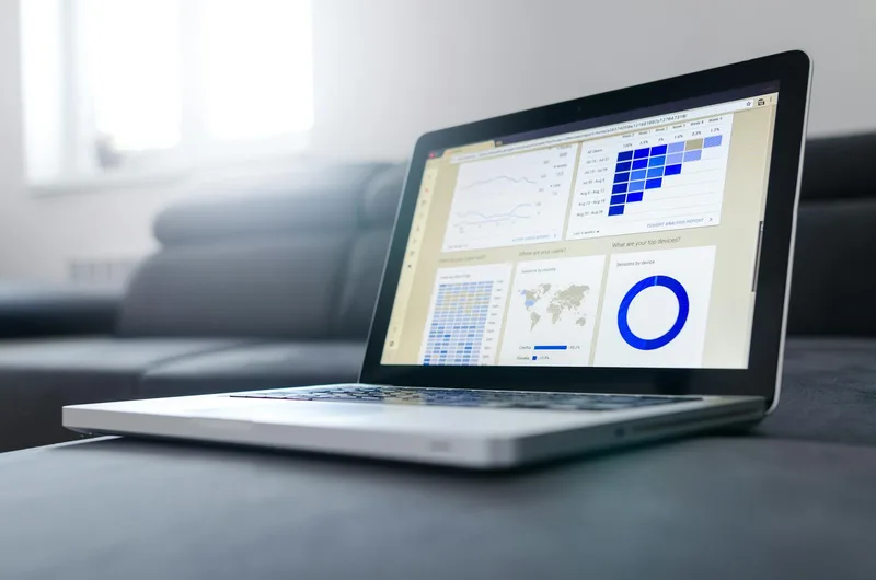 Laptop screen showing an email dashboard with a five-email sequence, open rates and click rates displayed per email