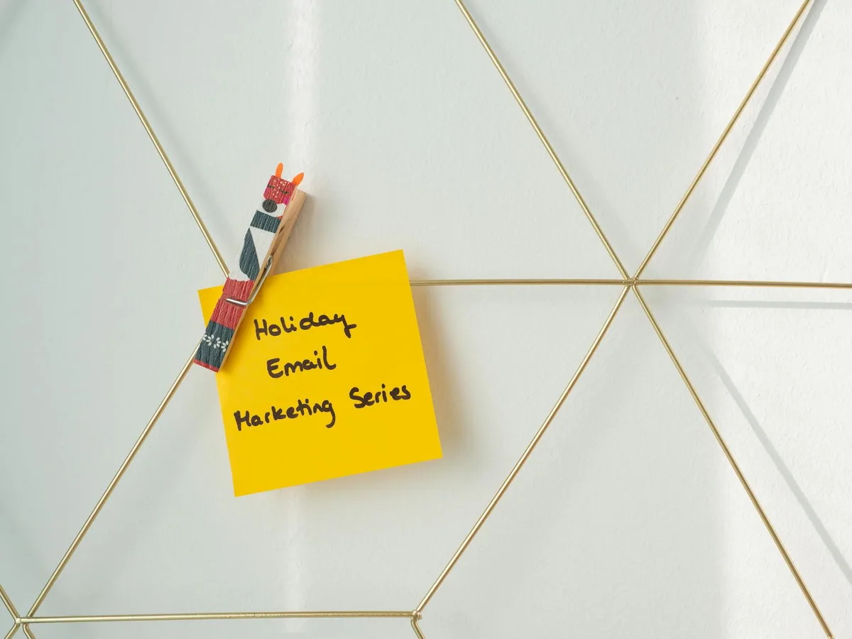 Sticky note with &ldquo;email marketing&rdquo; written on it against a coral background, representing the decision to choose an email tool for a creator business