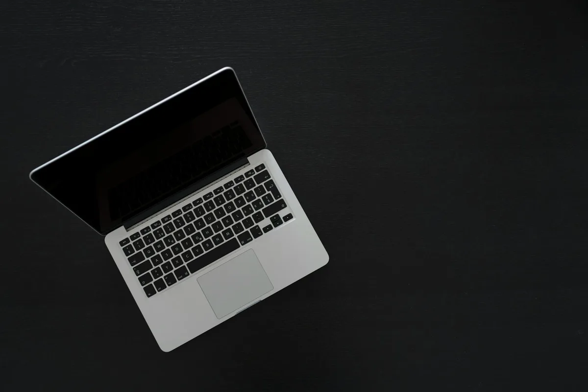 Creator at a desk reviewing course platform options on a laptop